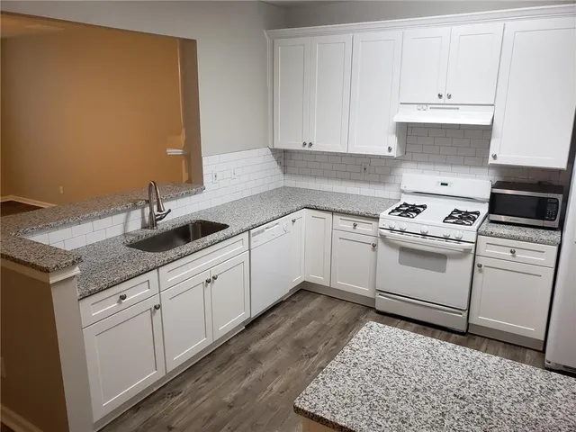 a kitchen with white cabinets and white appliances