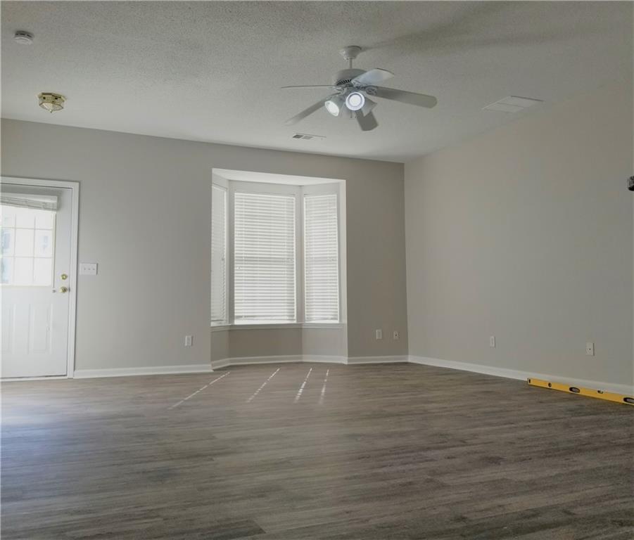 4081 Howell Park Road Duluth, GA 30096 - Photo 5 of 12 a view of an empty room with wooden floor and fan