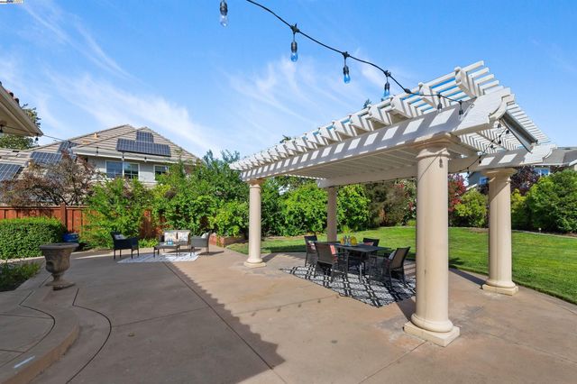 a view of a patio with a table chairs and a backyard