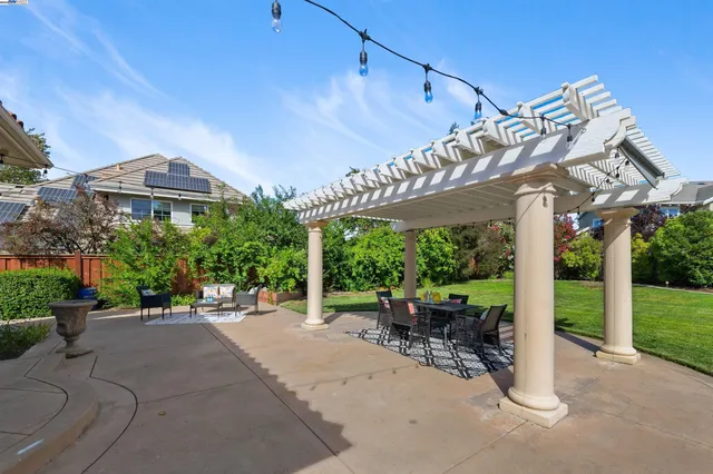 a view of a patio with a table chairs and a backyard