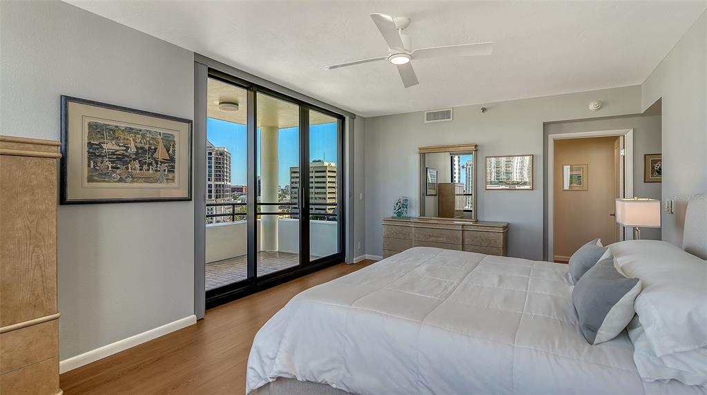 1255 North Gulfstream Avenue, Unit 1101 Sarasota, FL 34236 - Photo 36 of 75 a spacious bedroom with a large bed and a chandelier