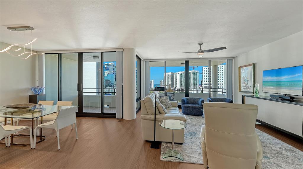 1255 North Gulfstream Avenue, Unit 1101 Sarasota, FL 34236 - Photo 10 of 75 a living room with furniture a flat screen tv and large windows