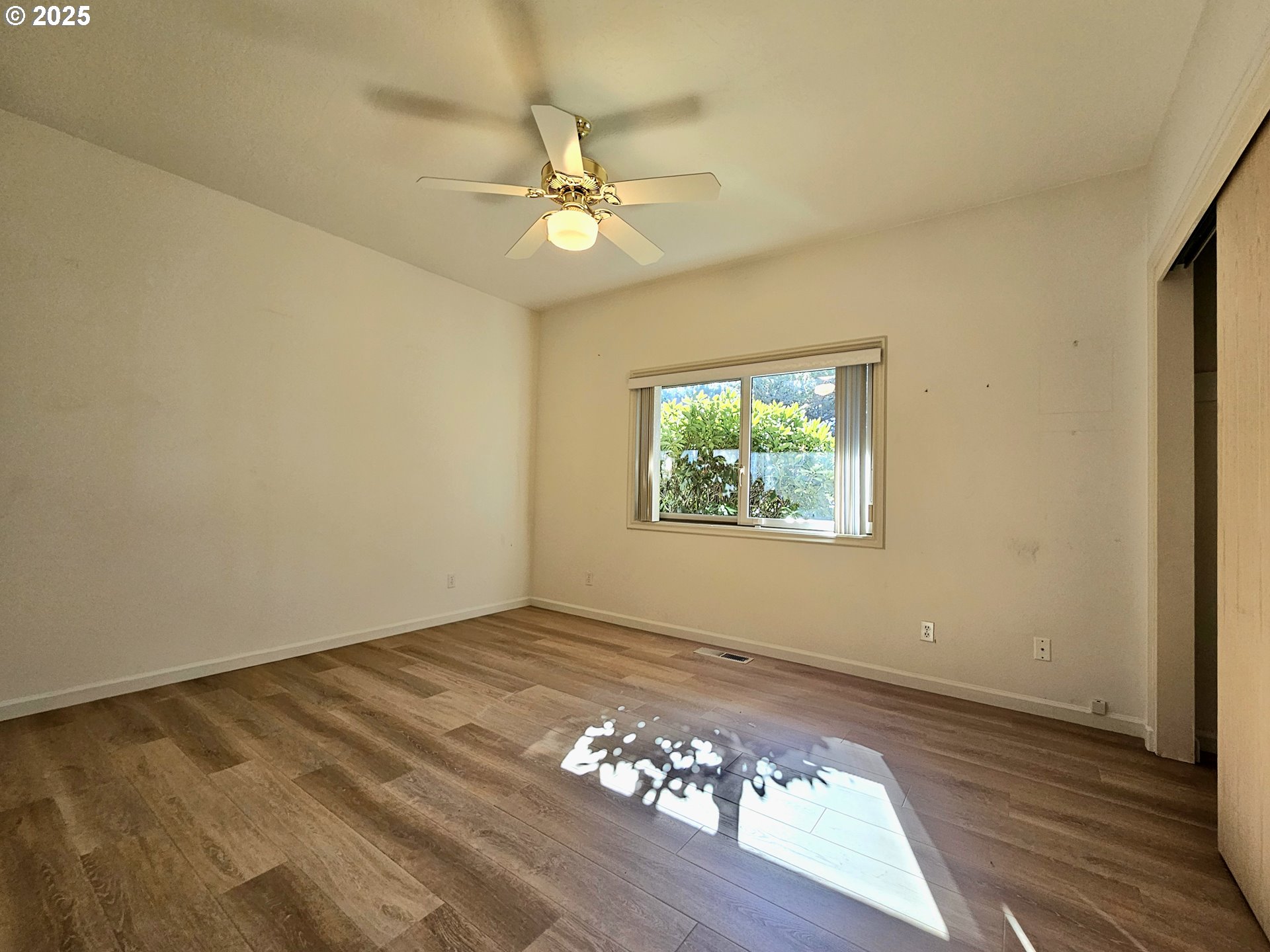 96448 Shorewood Terrace Brookings, OR 97415 - Photo 27 of 48 an empty room with wooden floor chandelier fan and windows