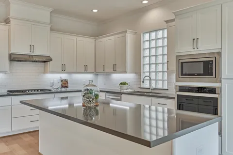a kitchen with stainless steel appliances granite countertop a sink stove and microwave