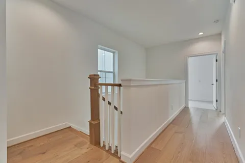 a view of a hallway with wooden floor and entryway