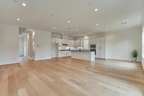 a view of kitchen with kitchen island a sink wooden floor and a refrigerator