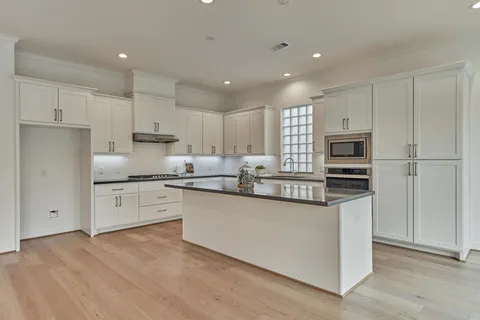 a large kitchen with stainless steel appliances granite countertop a stove a sink and a refrigerator