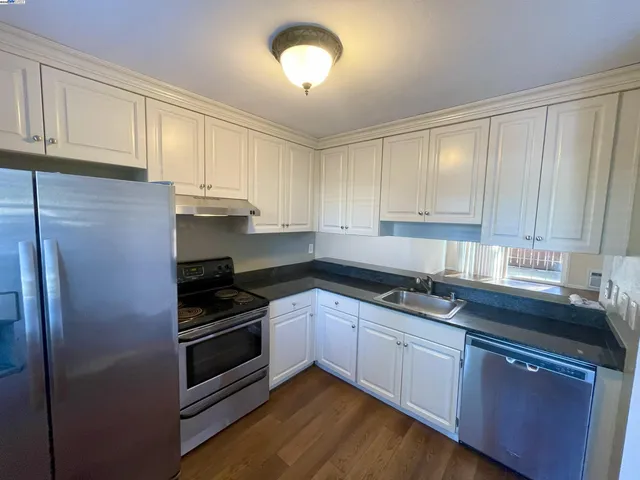 a kitchen with stainless steel appliances granite countertop a stove a sink and a refrigerator