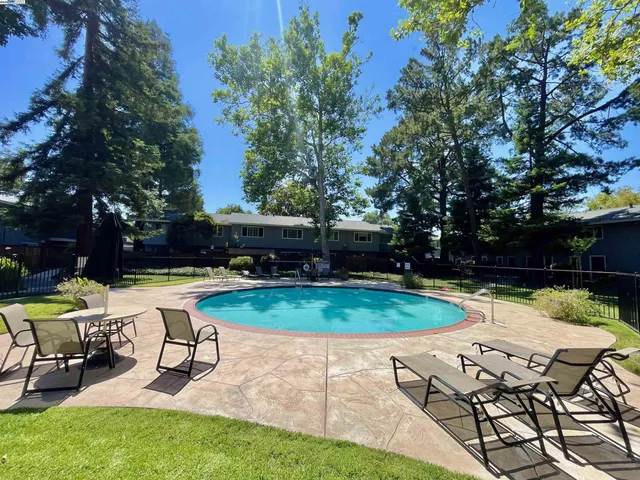 a view of backyard with swimming pool and sitting area