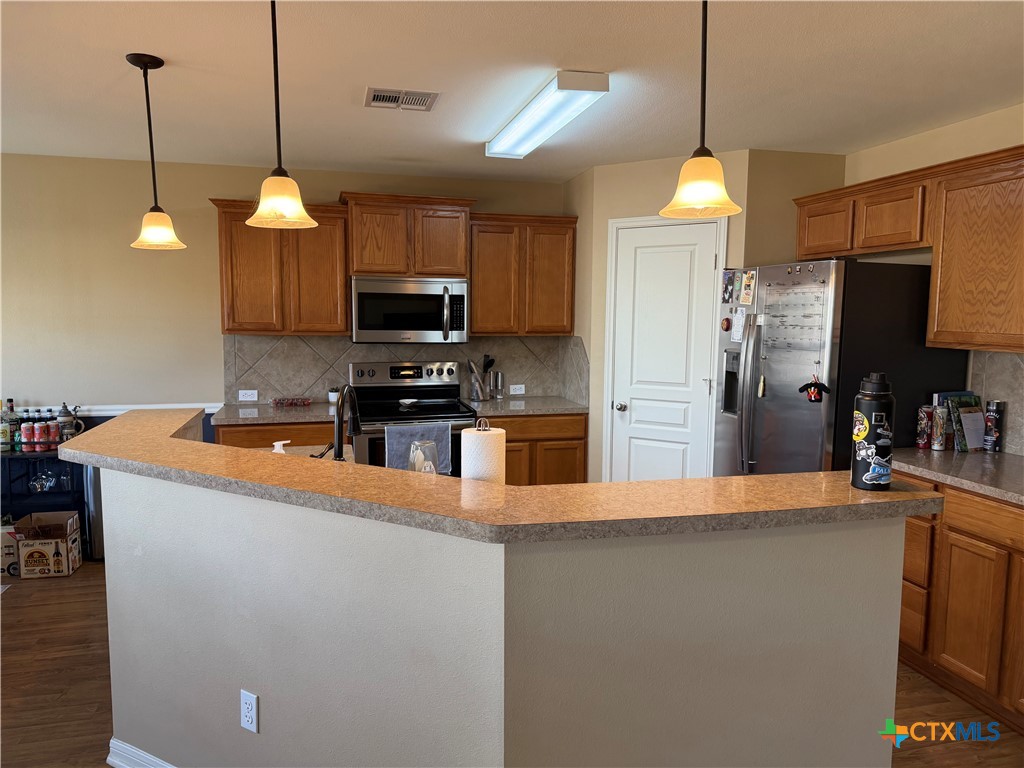1126 Neuberry Cliffe Temple, TX 76502 - Photo 3 of 19 a kitchen with stainless steel appliances granite countertop a refrigerator a sink a stove and a wooden floors