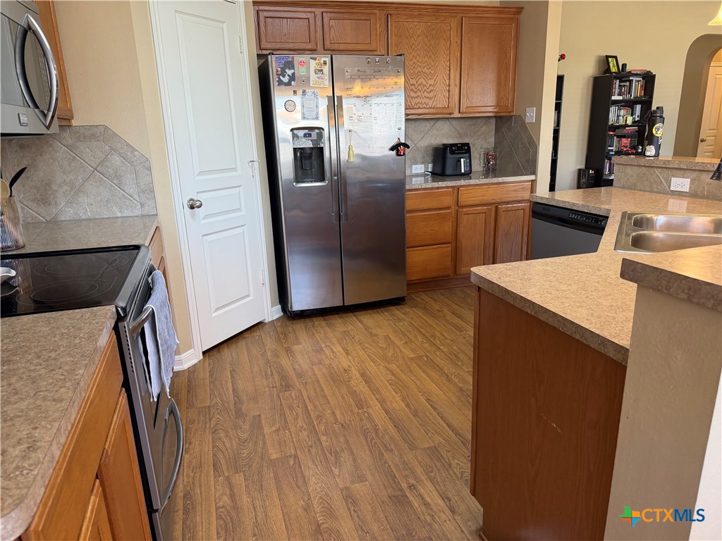 1126 Neuberry Cliffe Temple, TX 76502 - Photo 6 of 19 a kitchen with stainless steel appliances a refrigerator a sink a stove and white cabinets