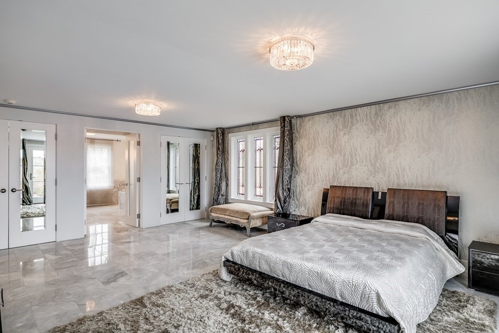 75 Great Hill Road Sandwich, MA 02563 - Photo 14 of 42 a bedroom with a bed and a chandelier