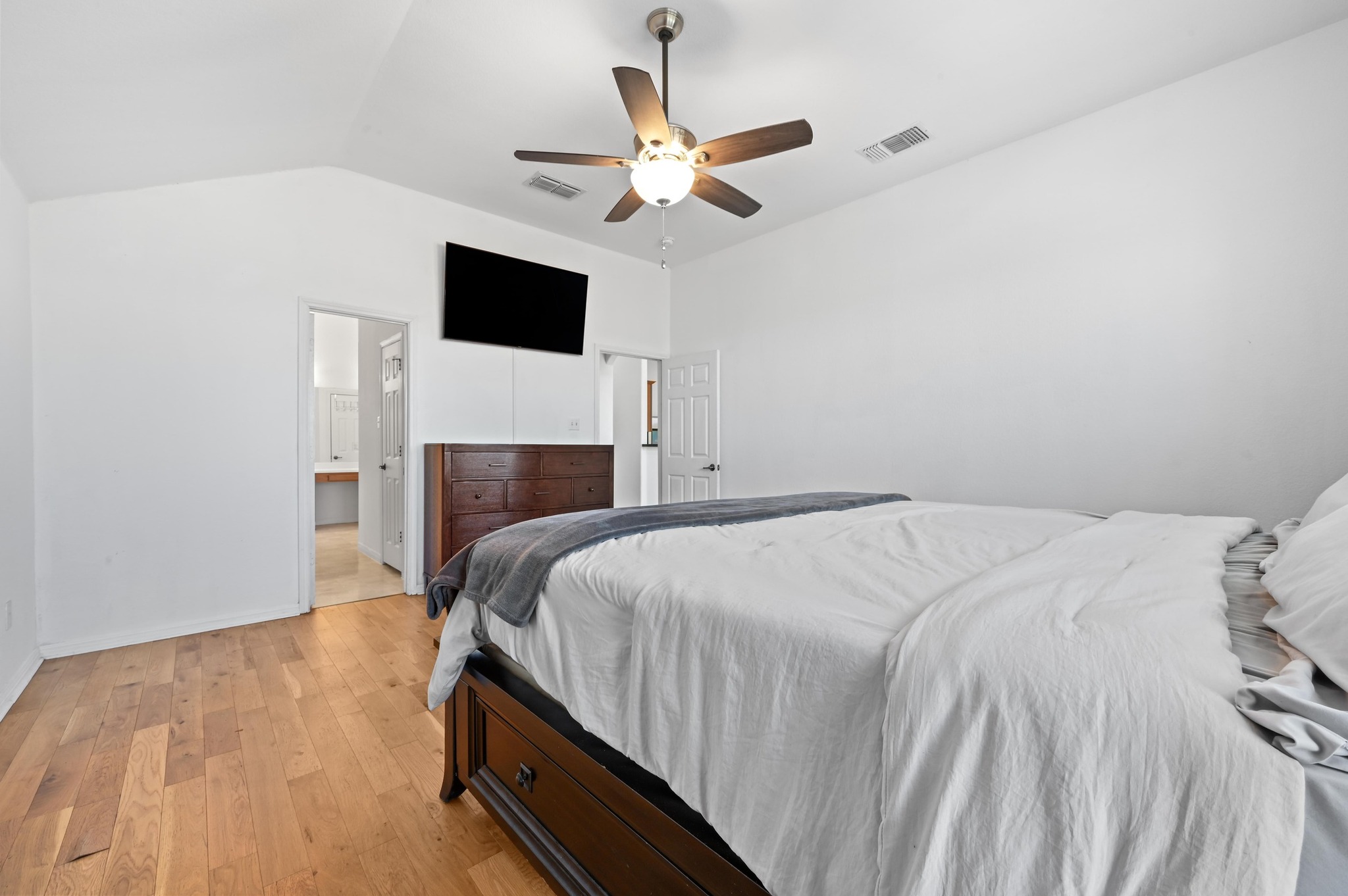 198 Valruth Drive Kyle, TX 78640 - Photo 21 of 32 Bedroom featuring light wood-style floors, ceiling fan, lofted ceiling, and connected bathroom