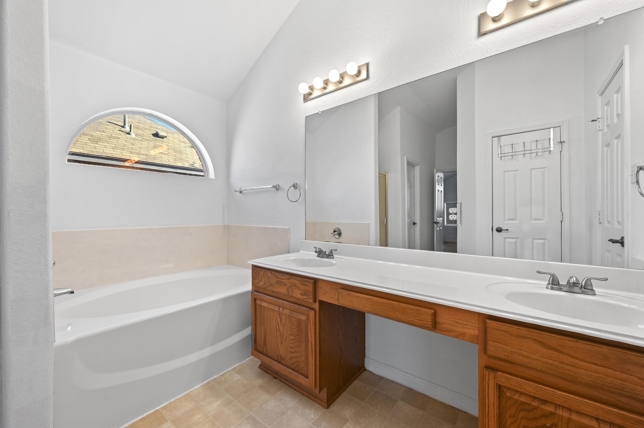 198 Valruth Drive Kyle, TX 78640 - Photo 22 of 32 Bathroom with a bath, double vanity, and vaulted ceiling