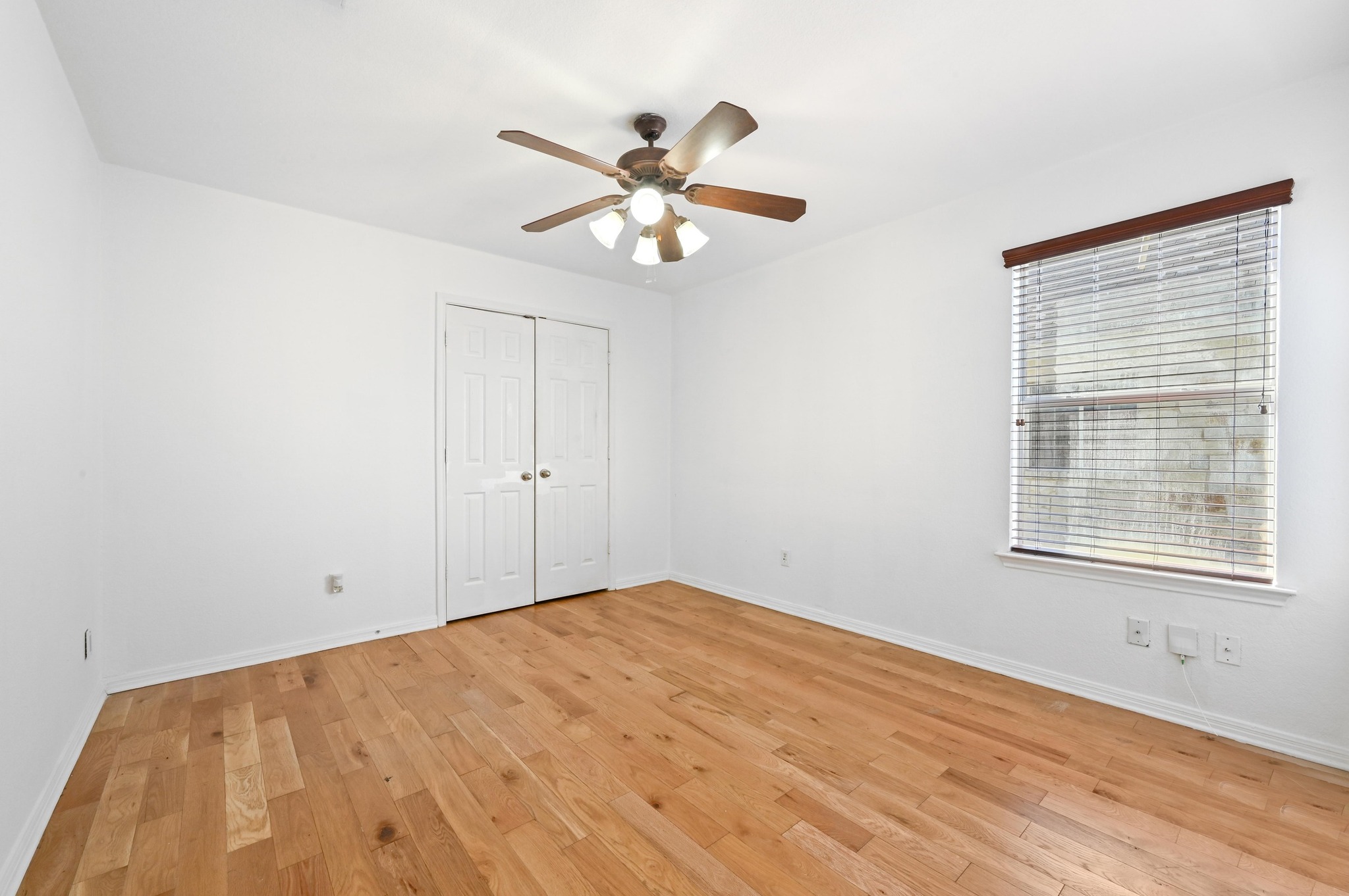 198 Valruth Drive Kyle, TX 78640 - Photo 24 of 32 Unfurnished bedroom with light wood finished floors, a ceiling fan, and a closet