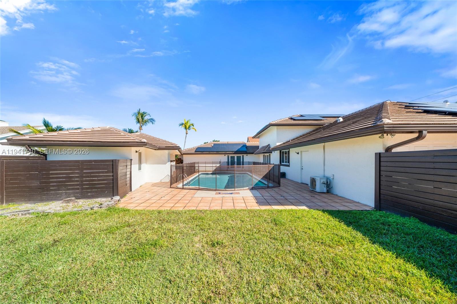 9461 Southwest 128th Street Miami, FL 33176 - Photo 19 of 24 a front view of a house with a yard and garage