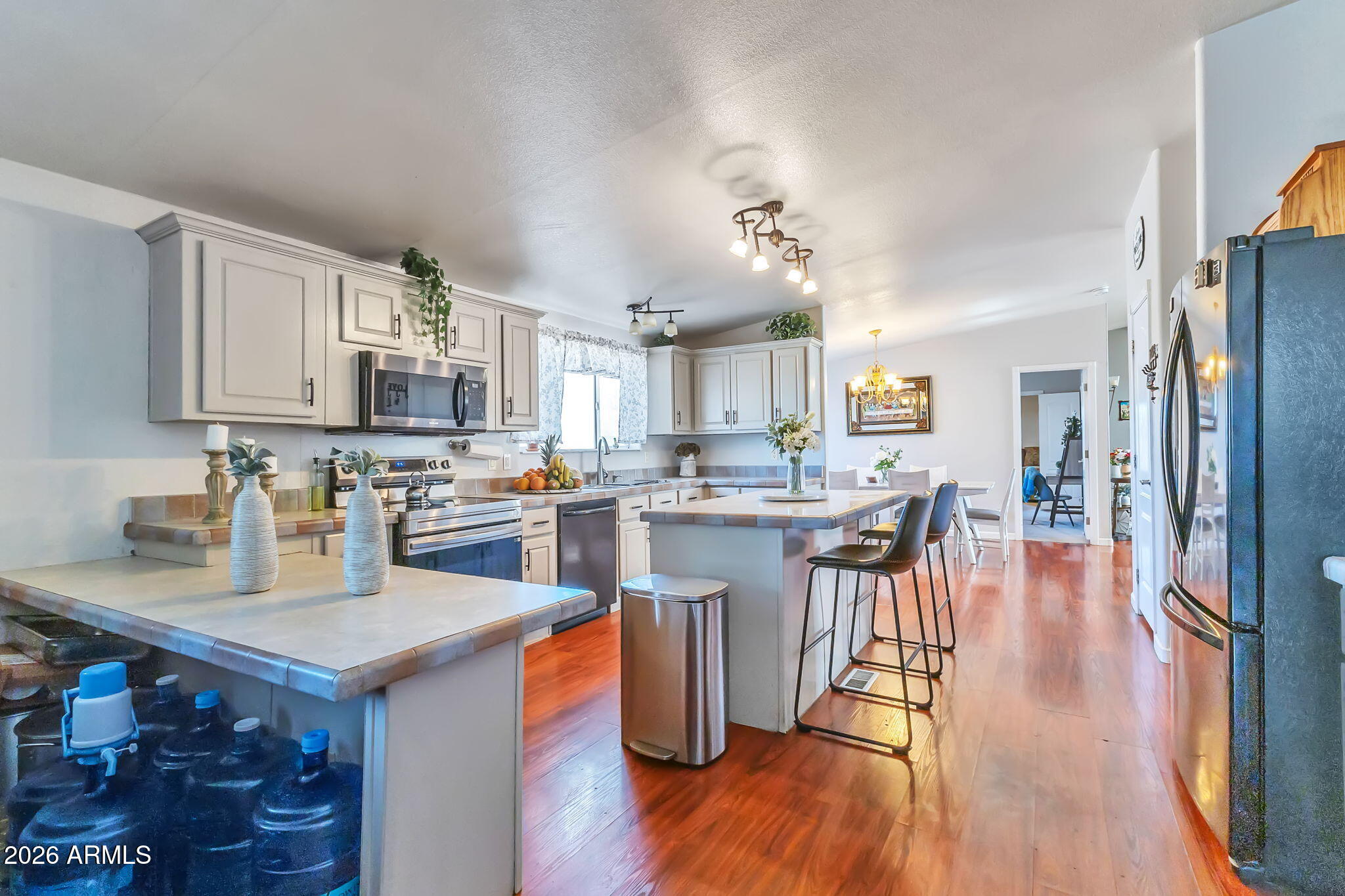 1236 West Judd Road San Tan Valley, AZ 85144 - Photo 17 of 28 a kitchen with stainless steel appliances granite countertop a refrigerator a stove top oven a sink dishwasher and white cabinets with wooden floor