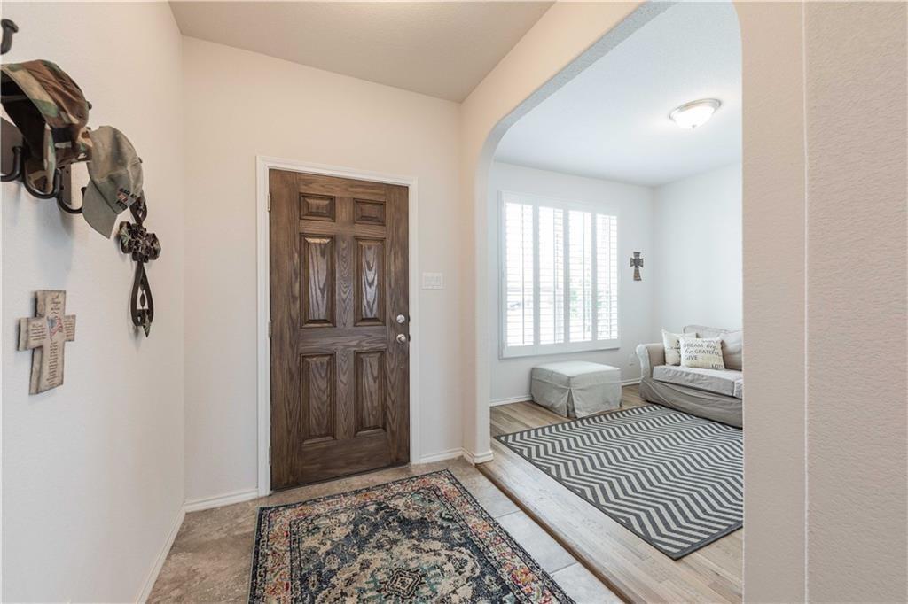 1716 Rio Penasco Road Fort Worth, TX 76052 - Photo 3 of 31 Archway entry leading to an interior space with wood-finish flooring, a window featuring plantation shutters, and an overhead light fixture