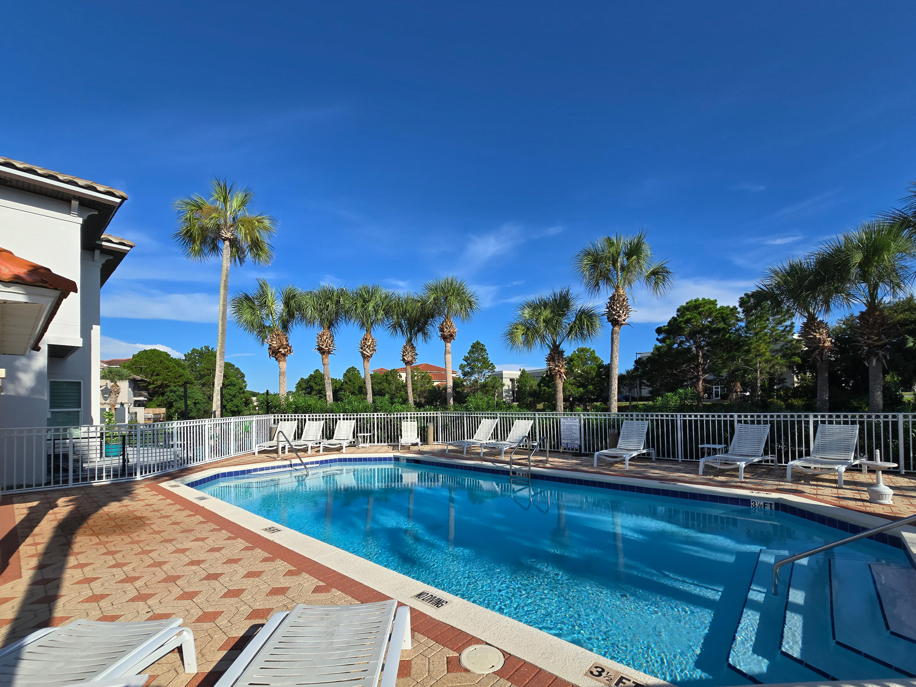 4707 Amhurst Circle Destin, FL 32541 - Photo 31 of 40 a view of a swimming pool with a bench and tables in patio