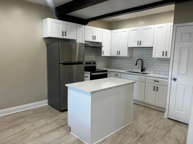 a kitchen with a stove and white cabinets