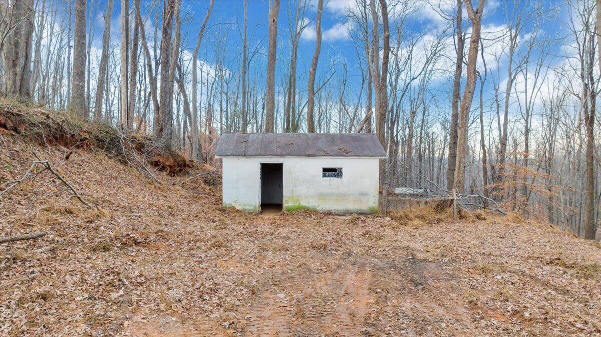585 Doe Run Road Rocky Mount, VA 24151 - Photo 9 of 30 a backyard of a house with a large tree and wooden fence