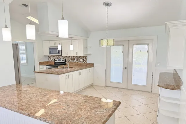 a kitchen with stainless steel appliances granite countertop a stove a sink and a refrigerator