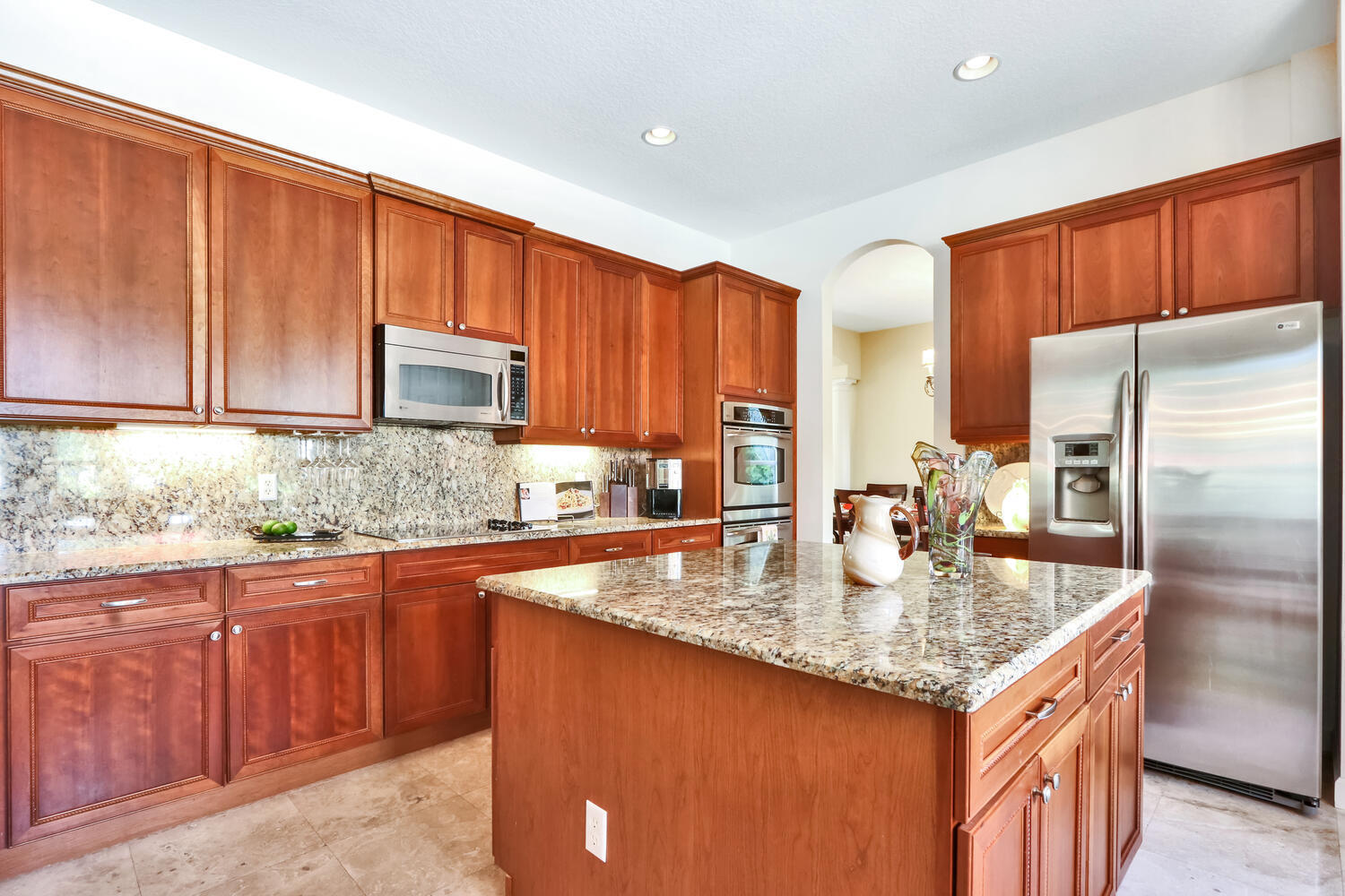 585 Southwest Yacht Basin Way Stuart, FL 34997 - Photo 10 of 31 a kitchen with stainless steel appliances granite countertop a stove a sink dishwasher a refrigerator and cabinets with wooden floor