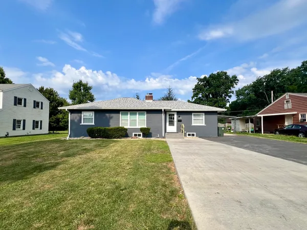 a front view of a house with a garden and yard