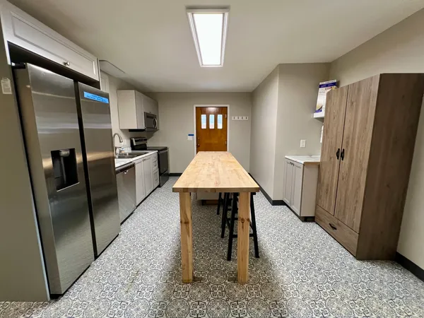 a kitchen with stainless steel appliances granite countertop a refrigerator and a stove top oven