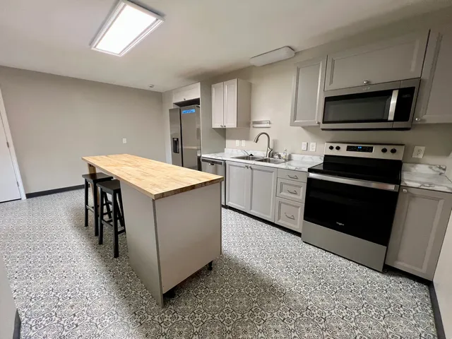 a kitchen with stainless steel appliances granite countertop a stove a sink and a microwave