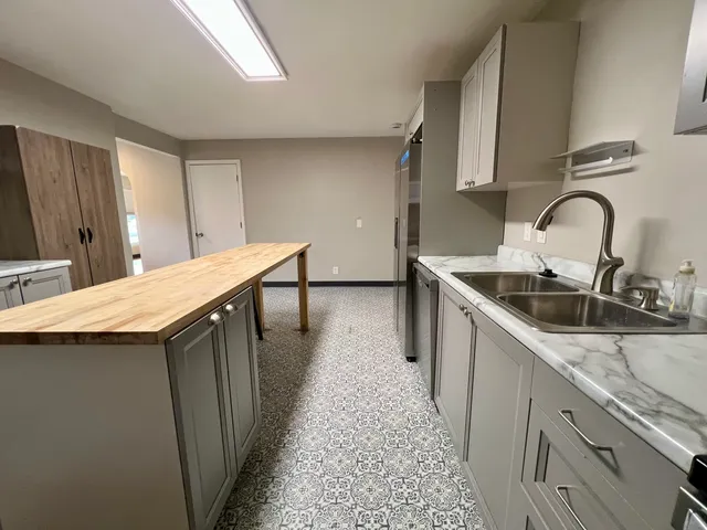 a kitchen with stainless steel appliances a sink a stove top oven a counter space and cabinets