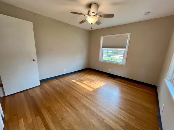 a view of room with window ceiling fan and hardwood floor