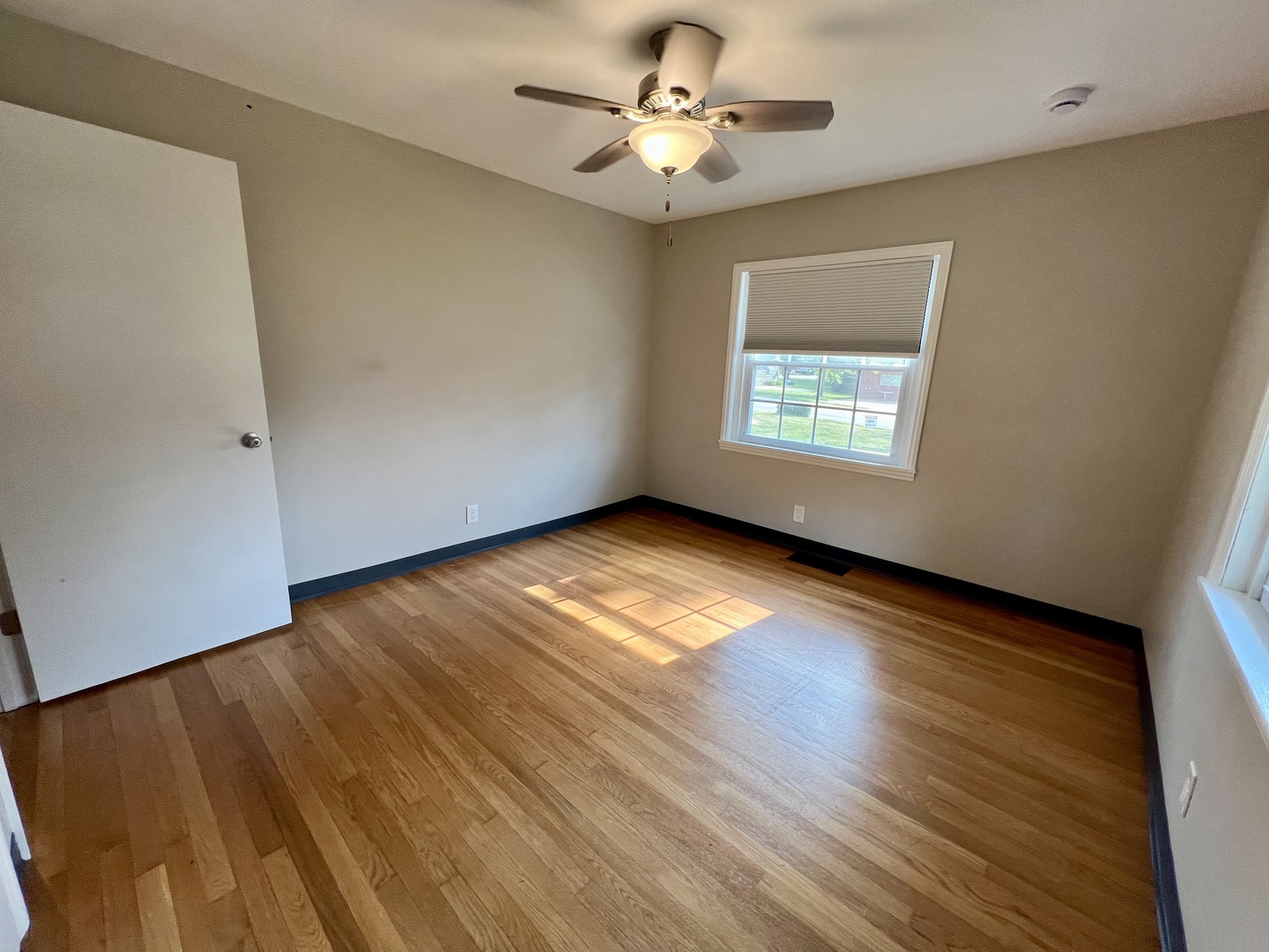 1528 Division Street Charleston, IL 61920 - Photo 20 of 45 a view of room with window ceiling fan and hardwood floor