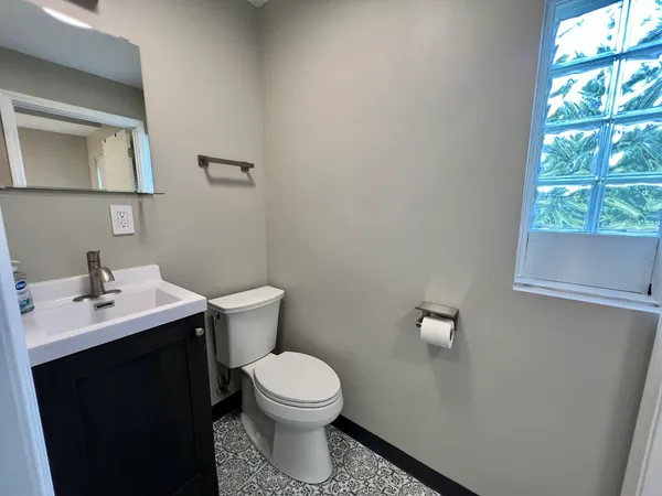 a bathroom with a toilet a sink and a window