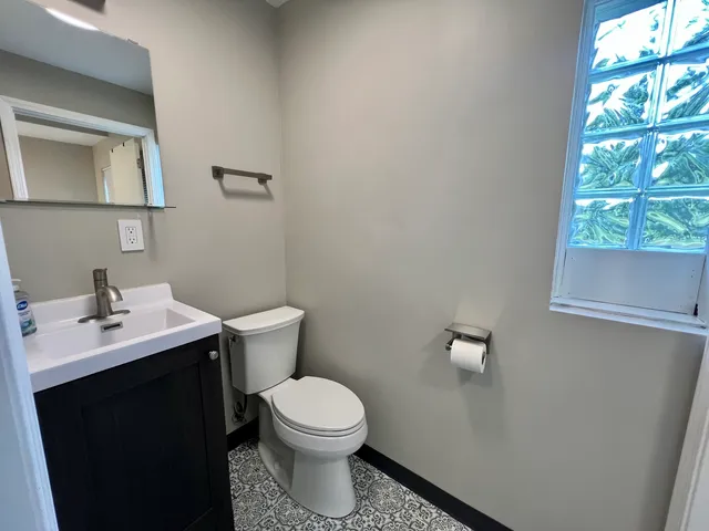 a bathroom with a toilet a sink and a window