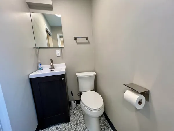 a bathroom with a toilet a sink and mirror