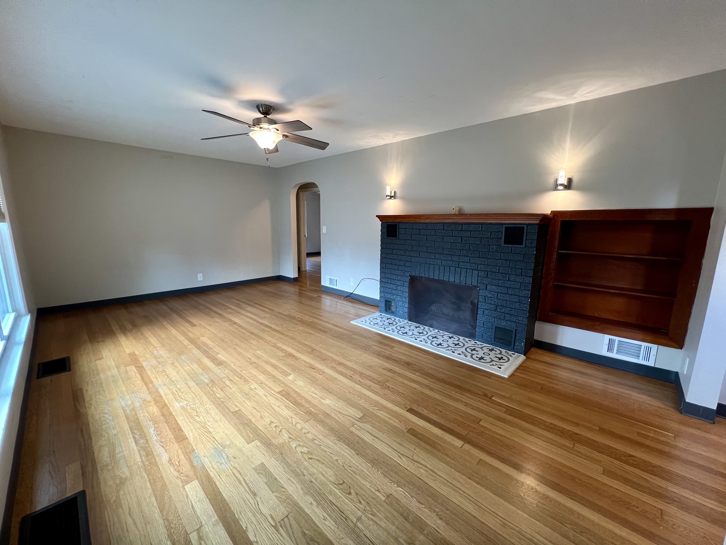 1528 Division Street Charleston, IL 61920 - Photo 5 of 45 a view of an empty room with wooden floor fireplace and a window