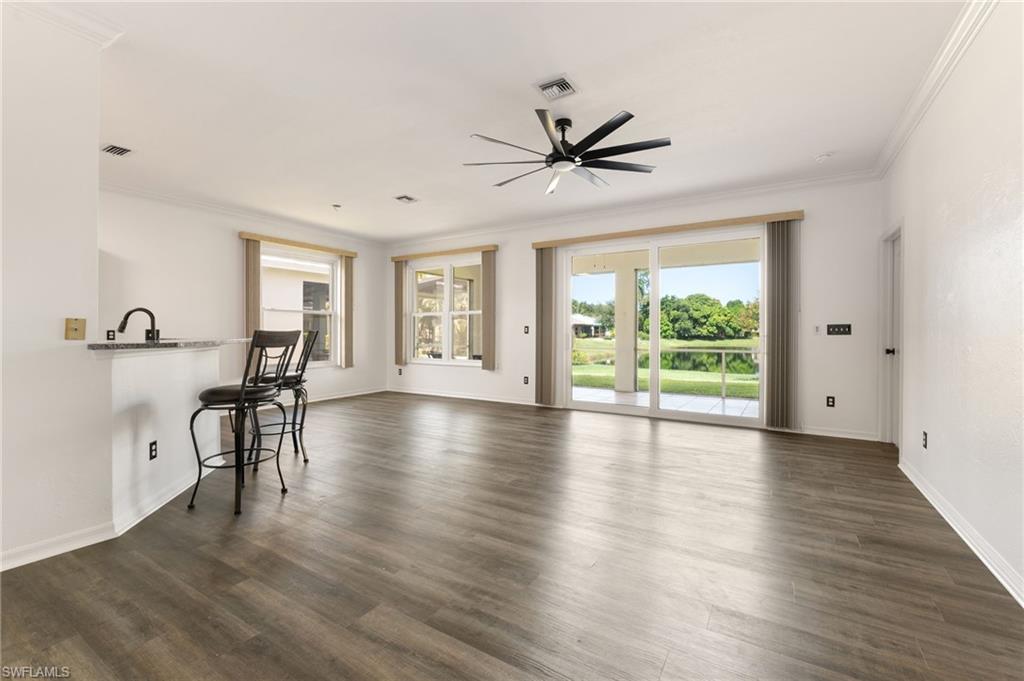 223 Stanhope Circle Naples, FL 34104 - Photo 3 of 41 Spacious open-concept interior featuring wood-finish flooring, crown molding, and a modern ceiling fan