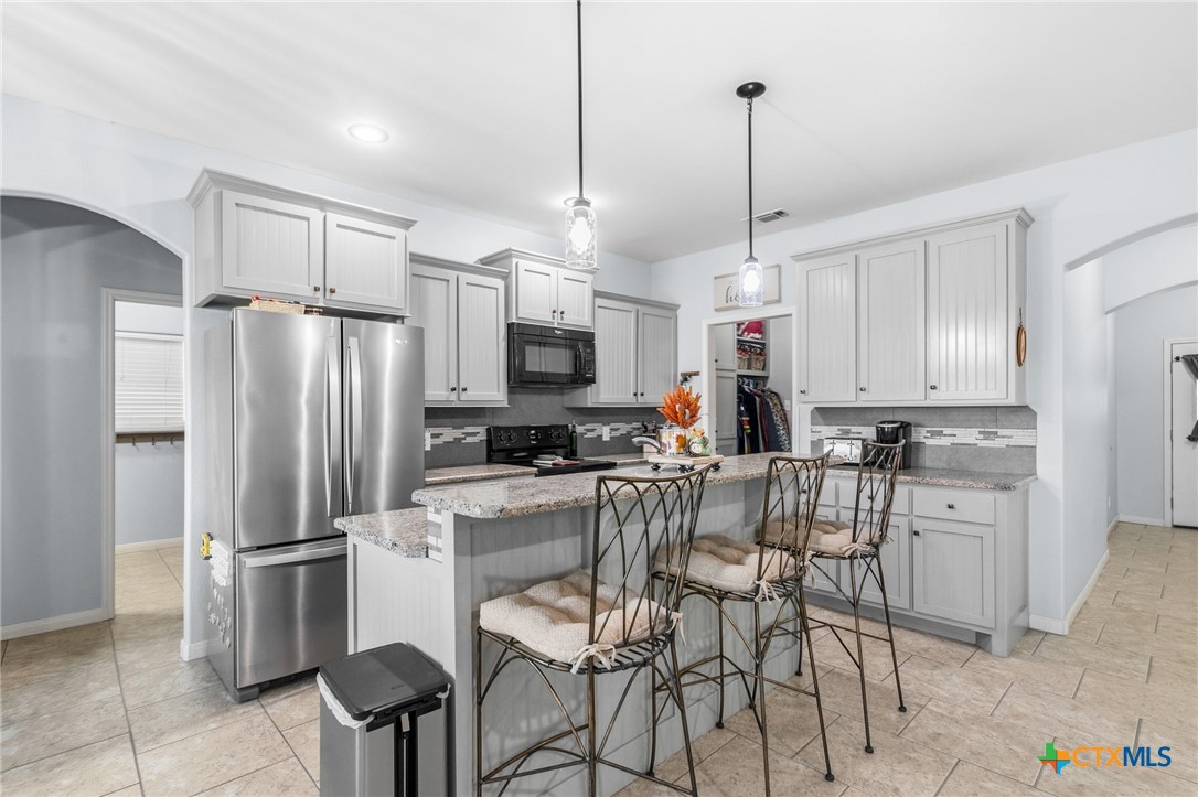 711 Mason Circle Victoria, TX 77904 - Photo 8 of 29 a kitchen with refrigerator cabinets and chairs