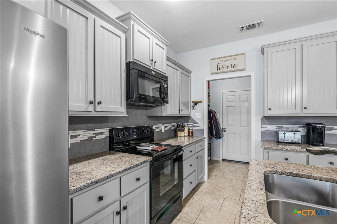 711 Mason Circle Victoria, TX 77904 - Photo 10 of 29 a kitchen with granite countertop a sink a stove and a microwave