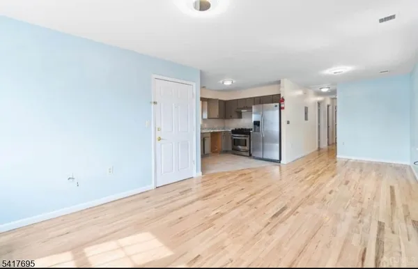 a view of empty room with wooden floor