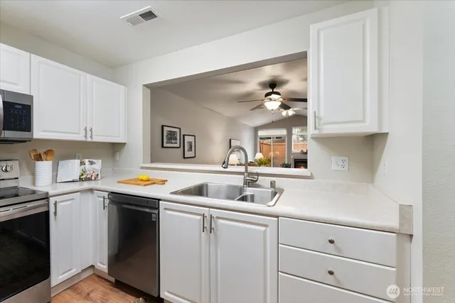 a kitchen with cabinets a sink and appliances
