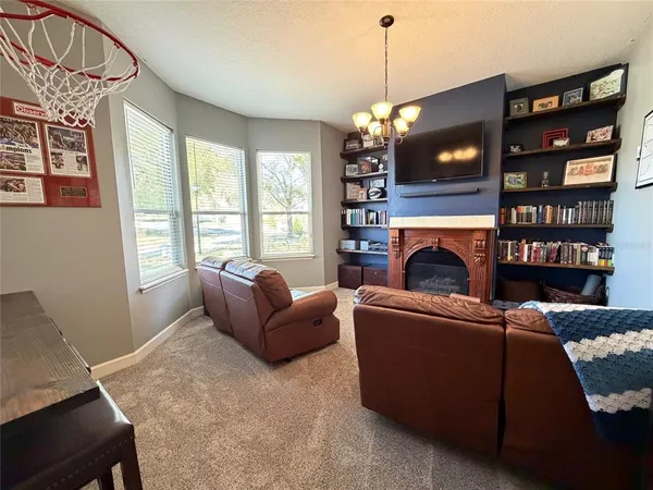 a living room with furniture a window and a flat screen tv