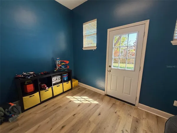 a wooden floor in a bedroom next to a window