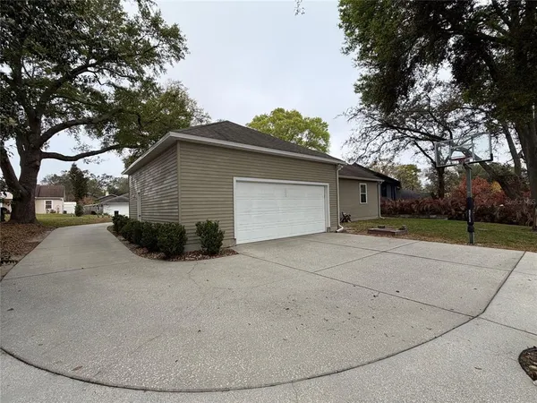 a view of a house with a yard and large tree