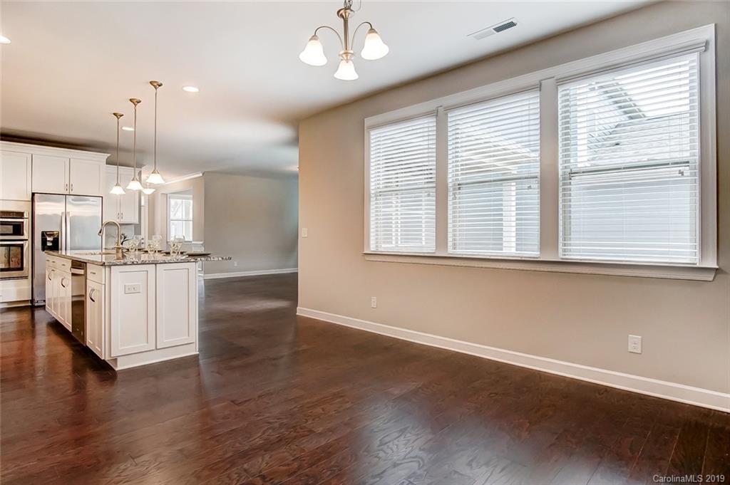 1280 Independence Street, Unit 58 Tega Cay, SC 29708 - Photo 13 of 31 a view of an empty room with wooden floor and kitchen view