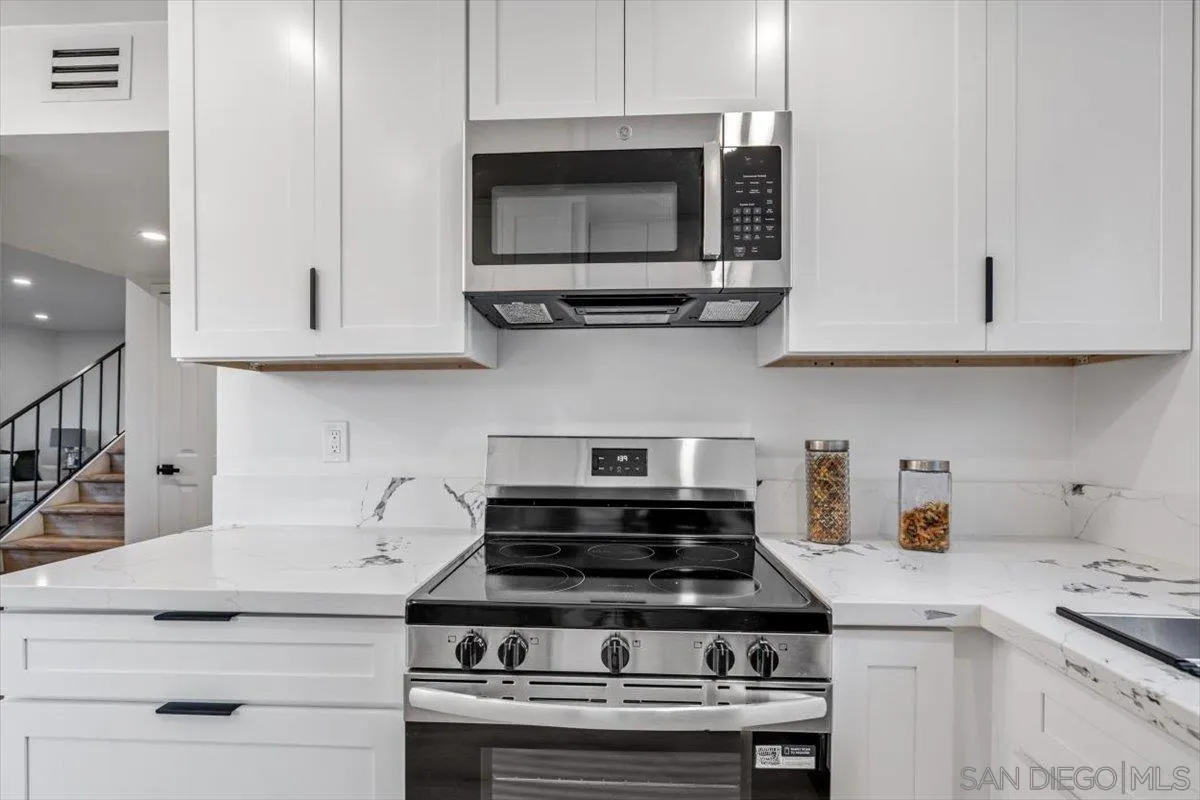 13259 Saddle Ridge Road Lakeside, CA 92040 - Photo 17 of 57 a kitchen with stainless steel appliances granite countertop white cabinets and a stove a oven with white countertops