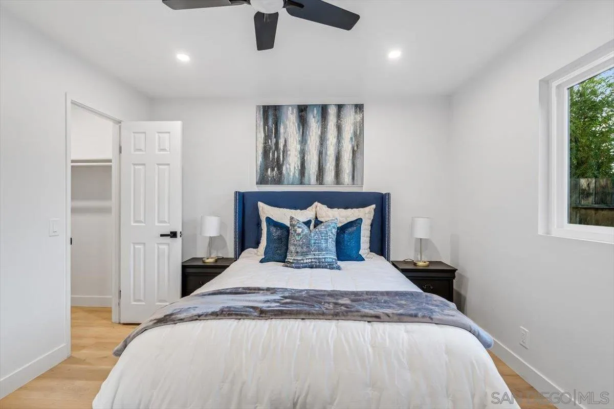 13259 Saddle Ridge Road Lakeside, CA 92040 - Photo 25 of 57 a bed sitting in a spacious bedroom next to a window and a chandelier