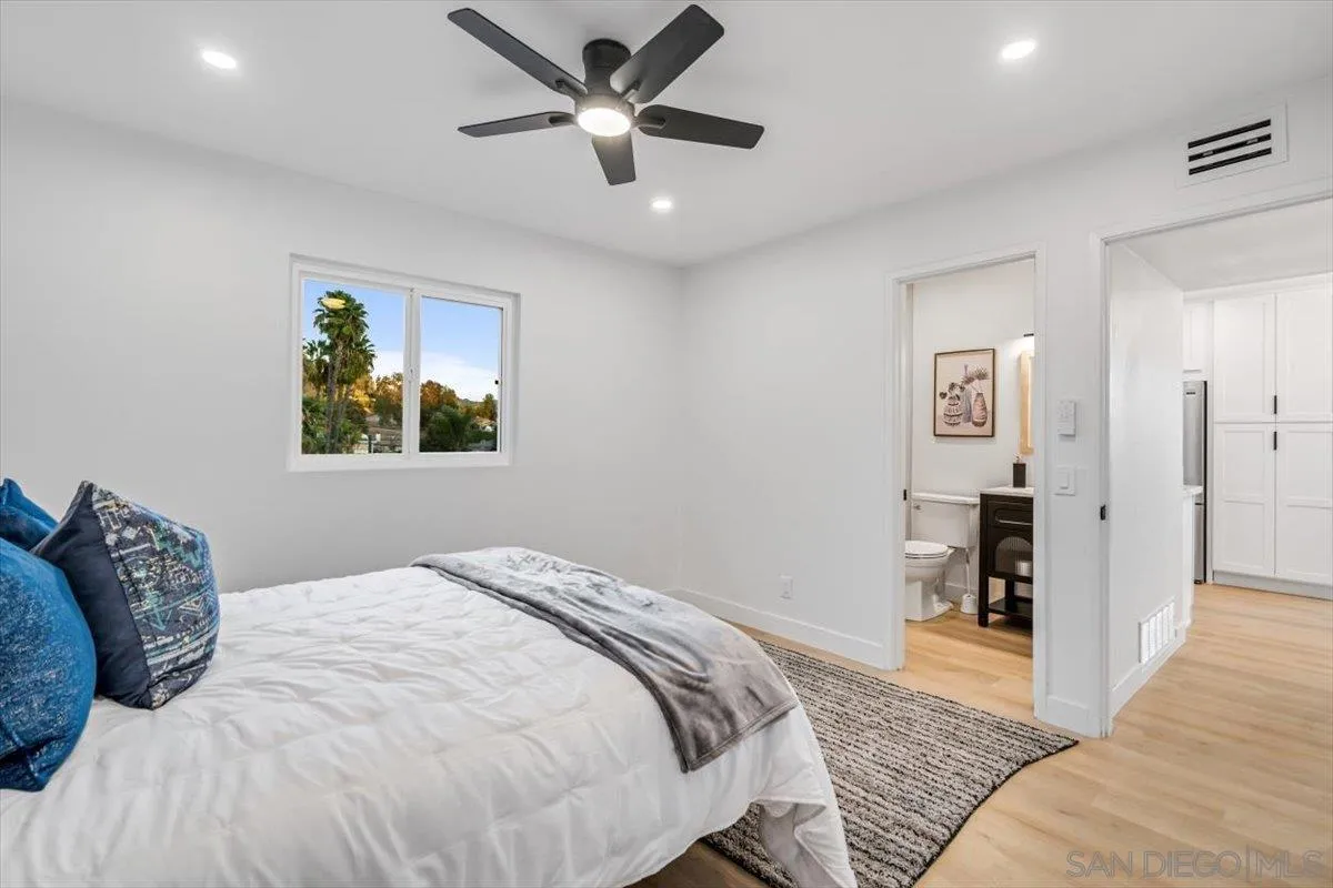 13259 Saddle Ridge Road Lakeside, CA 92040 - Photo 28 of 57 a bedroom with a large bed and a chandelier