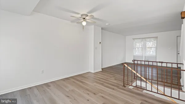 a view of a room with wooden floor and fan